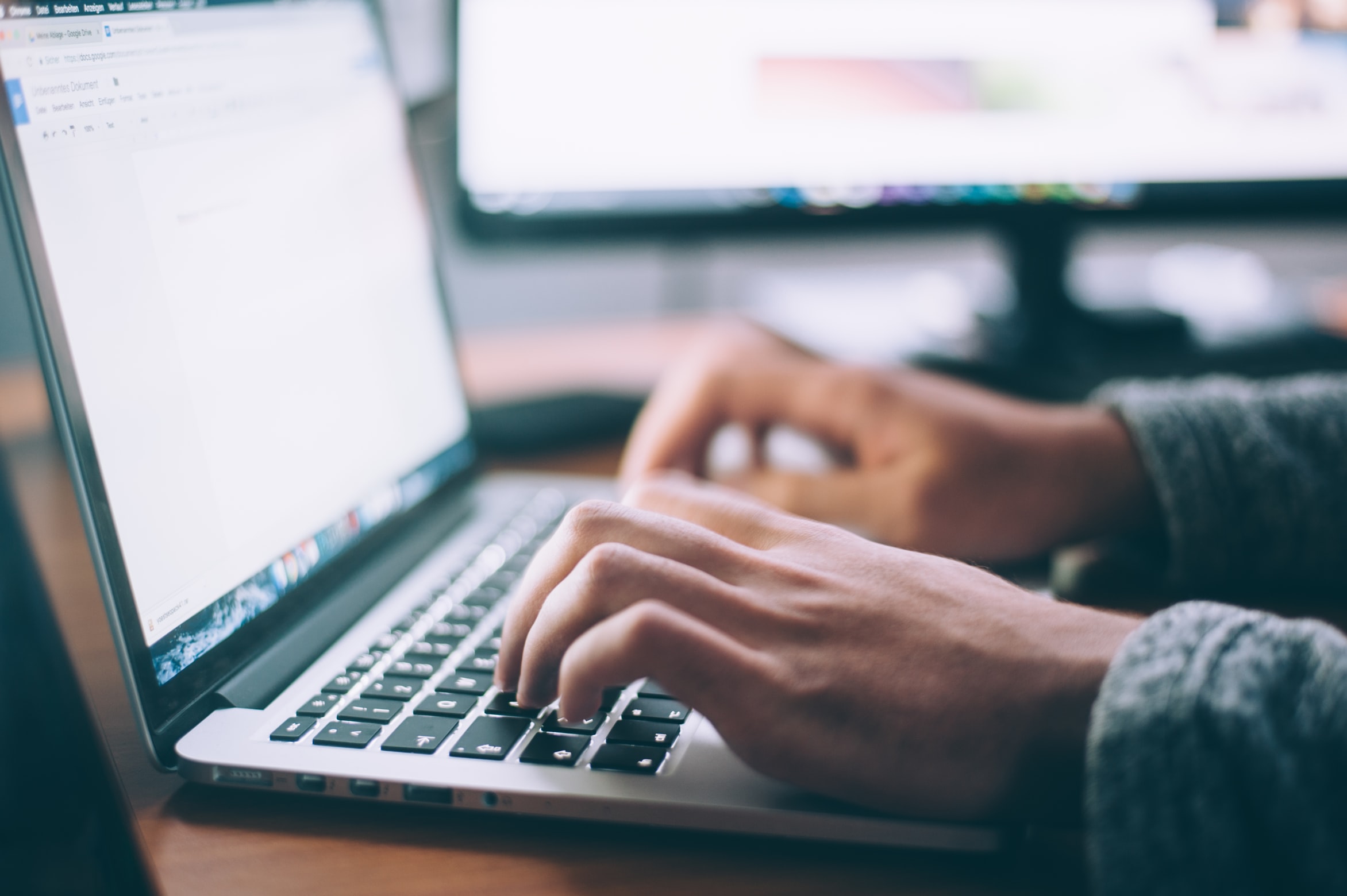 man typing on a laptop