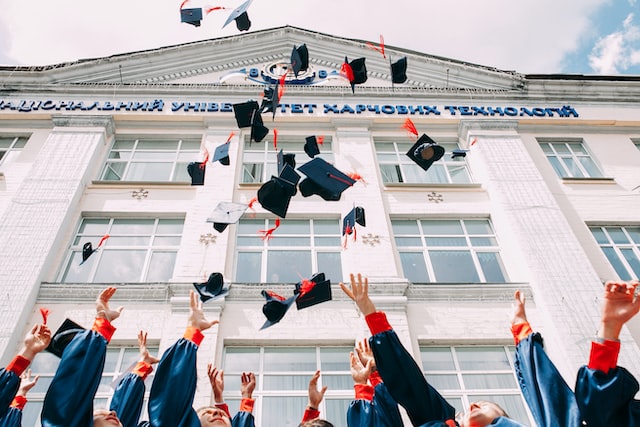 recent college graduates throwing their caps in the air